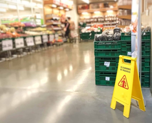 Wet Floor Sign in Front of Crates in Grocery Store