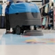Image of a worker buffing tile floors in a retail store.