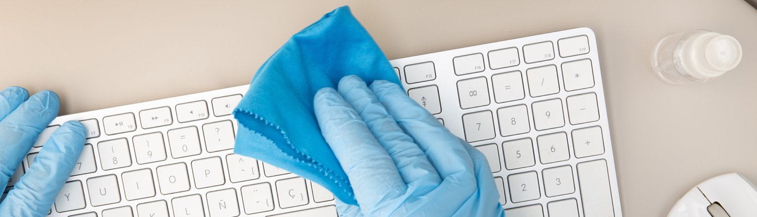 Overhead view of a person wiping off a keyboard Overhead View Of A Person Wiping Off A Keyboard