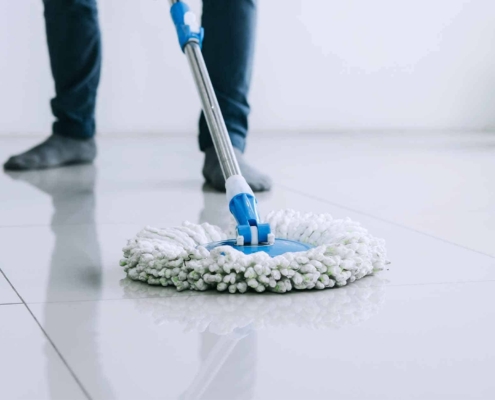 housekeeping and cleaning concept Happy young man in blue rubber gloves