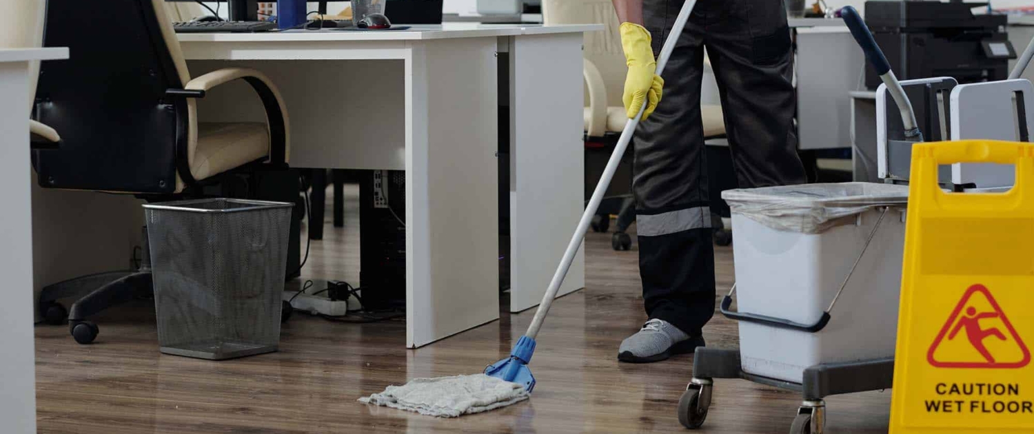 man-in-workwear-cleaning-floor-in-openspace-office-in man in workwear cleaning floor in openspace office in