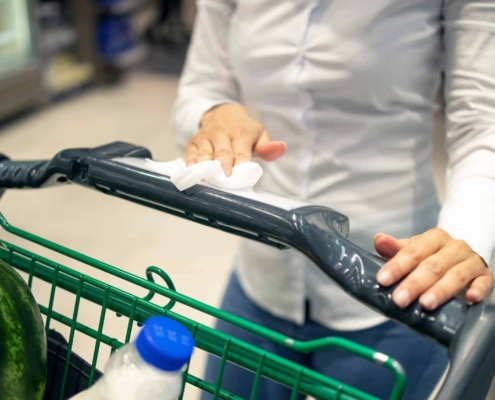 woman wiping a shopping cart