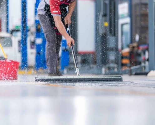 Janitor cleaning floor of warehouse