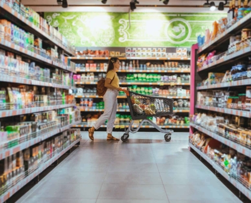 woman with shopping between store shelf