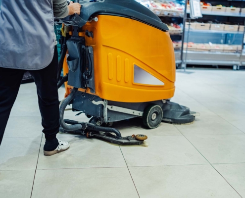 Worker Using Machine To Clean Retail Floors