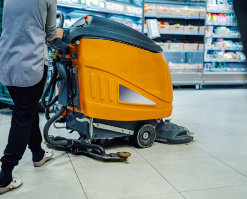 Janitor Cleaning Supermarket Floor With A Scrubber Dryer Machine