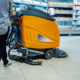 Janitor Cleaning Supermarket Floor With A Scrubber Dryer Machine