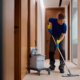 Commercial Cleaner Using Mop While Cleaning Office Hallway